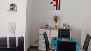 Un comedor moderno con una mesa, sillas y un equipo de aire acondicionado en la pared.