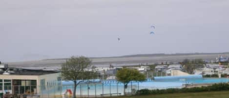 Ein Gebäude mit Schwimmbad, einem eingezäunten Bereich und einer Rasenfläche.
