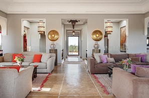 A spacious living room with two sofas, a coffee table, and decorative vases.