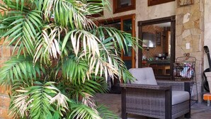 An outdoor patio area with a wicker sofa, a dining table, and a variety of potted plants. - Linda Propiedad de 5 Habitaciones (La Paz)