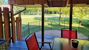 A covered outdoor seating area with a view of a green landscape and trees. - The Davis Loft - Perfect Location (Davis)