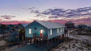 Una casa a la costa amb un balcó, una escala i vistes al mar.