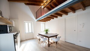Una cocina amplia con zona de comedor, vigas de madera en el techo y una puerta blanca.