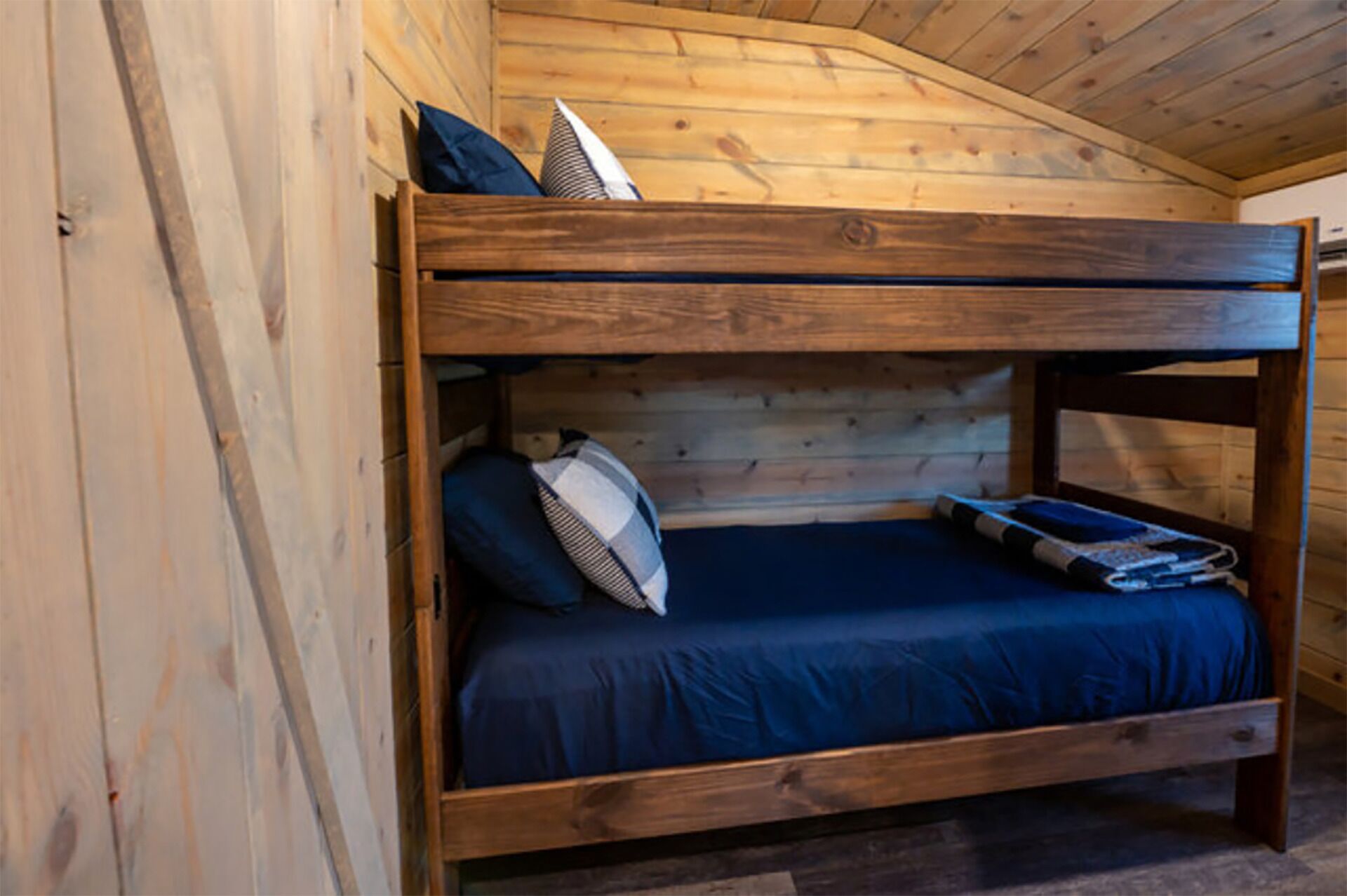 A bunk bed with a wooden headboard and a blue mattress.