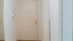 A narrow hallway with a white door at the end. - fully furnished 2-room apartment in Berlin (Berlin)