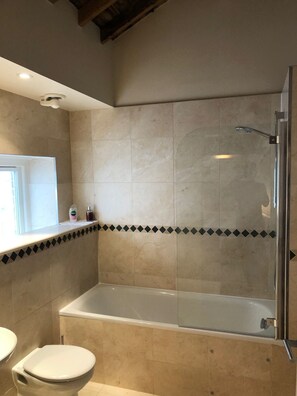 Ein Badezimmer mit einer Badewanne, Toilette und Waschbecken.
