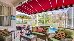 Un espace extérieur aménagé avec des meubles en osier, une piscine et une vue sur le paysage.