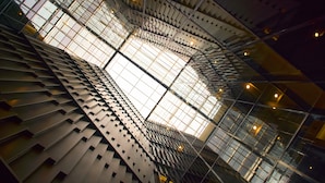 Una estructura arquitectónica moderna con un diseño geométrico y un amplio tragaluz central.