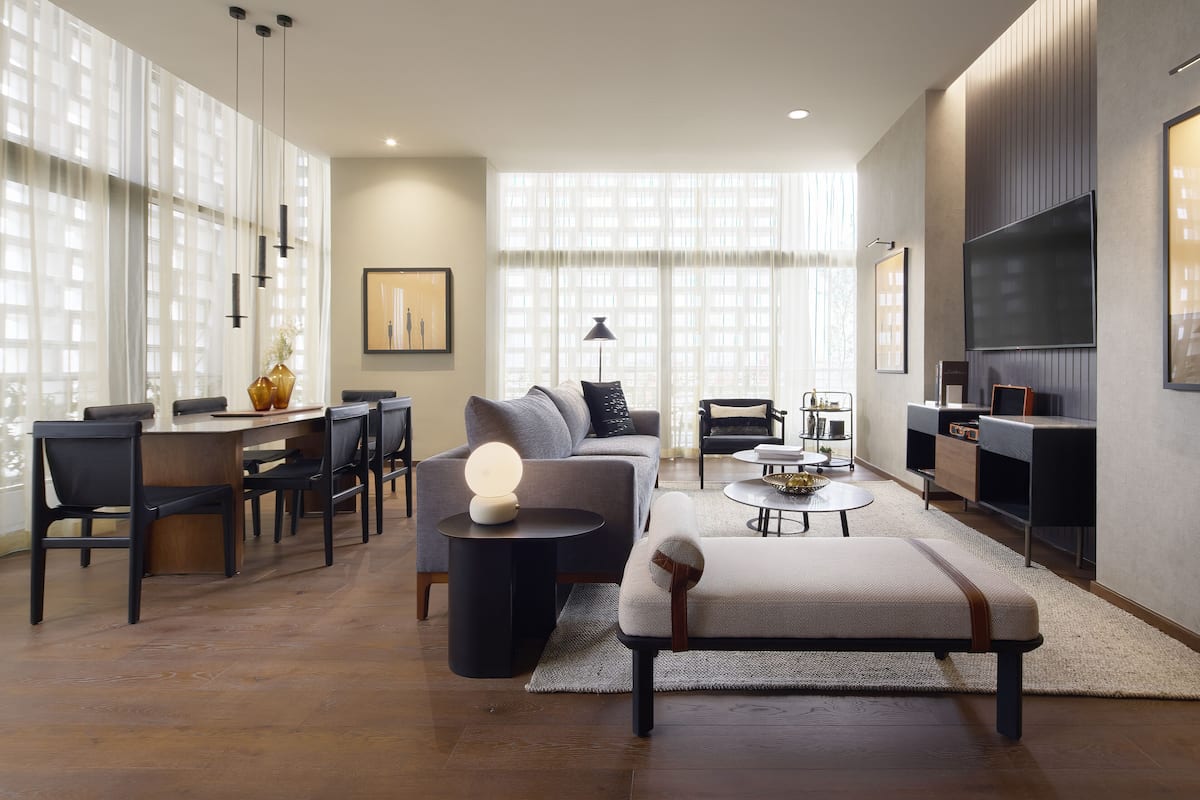 A modern living room with a sofa, coffee table, and dining area.