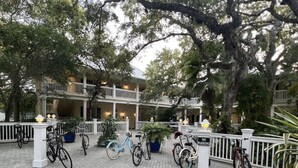 A courtyard with bicycles parked along a white fence, a building with balconies, and a 'No Parking' sign. - Country Club Beach Vacation (Vero Beach)