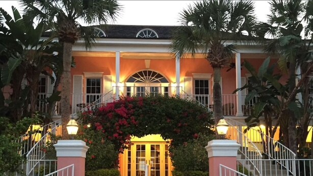 A hotel entrance with a central archway, steps leading up to it, and a well-lit facade. - Country Club Beach Vacation (Vero Beach)