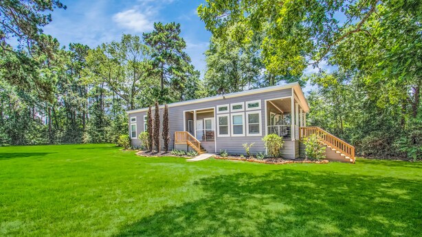 A modern house with a covered porch, a staircase, and a well-maintained lawn. - The Lantana Tiny Home  ~ Cottage in the Woods ~ NEW HOT TUB & DOGGY PLAY YARD (Willis)
