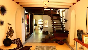 A modern interior with a staircase, a patterned rug, and a chair. - Esciros Luxury Villa (Progreso)