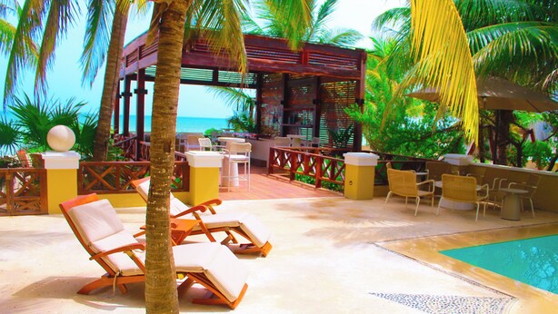A poolside area with lounge chairs, a small pool, and a wooden pergola overlooking the ocean. - Esciros Luxury Villa (Progreso)