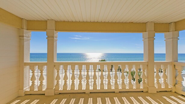 Un balcón techado con vistas al mar.
