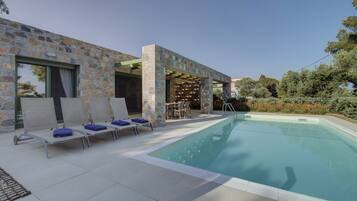 Una piscina al aire libre de temporada, tumbonas