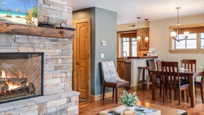 Una sala acogedora con chimenea de piedra, mesa de comedor de madera y asientos cómodos.