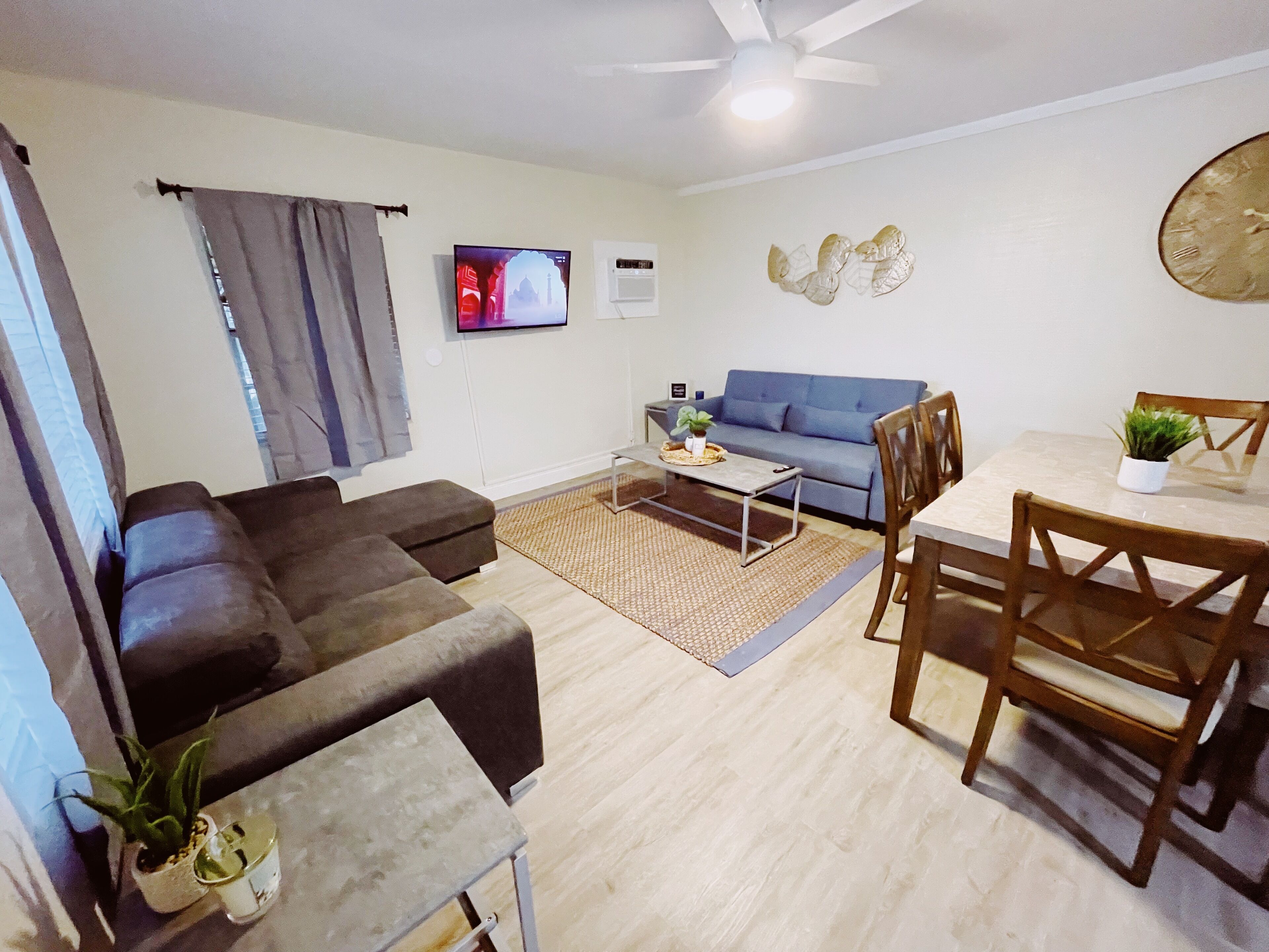 Ein Wohnzimmer mit einer Couch, einem Couchtisch und einem Esstisch mit Stühlen.