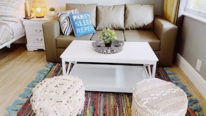 A modern living room with a beige sofa, white coffee table, and colorful striped rug. - Sea Steps by Lowkl (Pompano Beach)