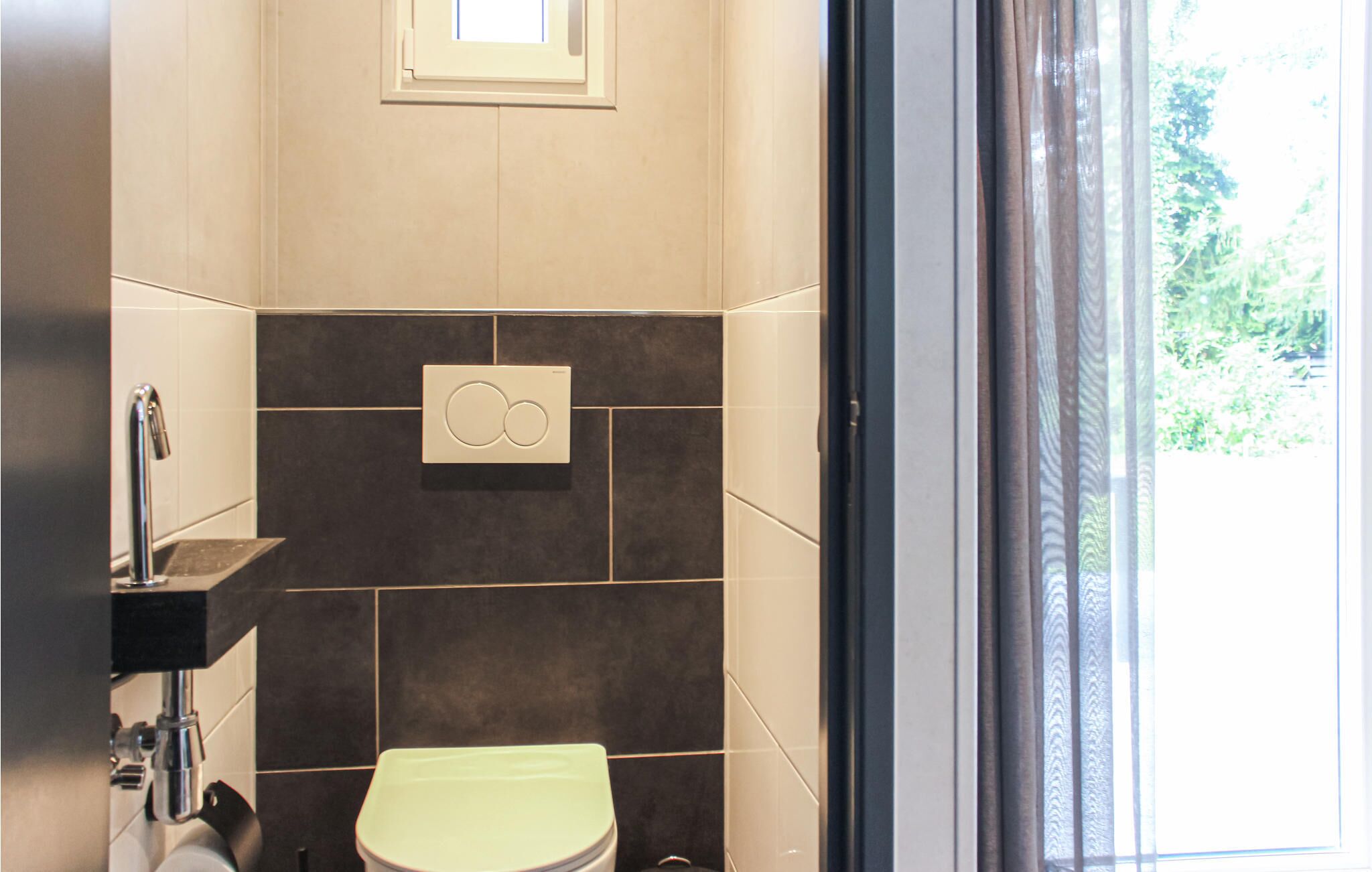 Ein modernes Badezimmer mit Toilette, Waschbecken und Dusche.