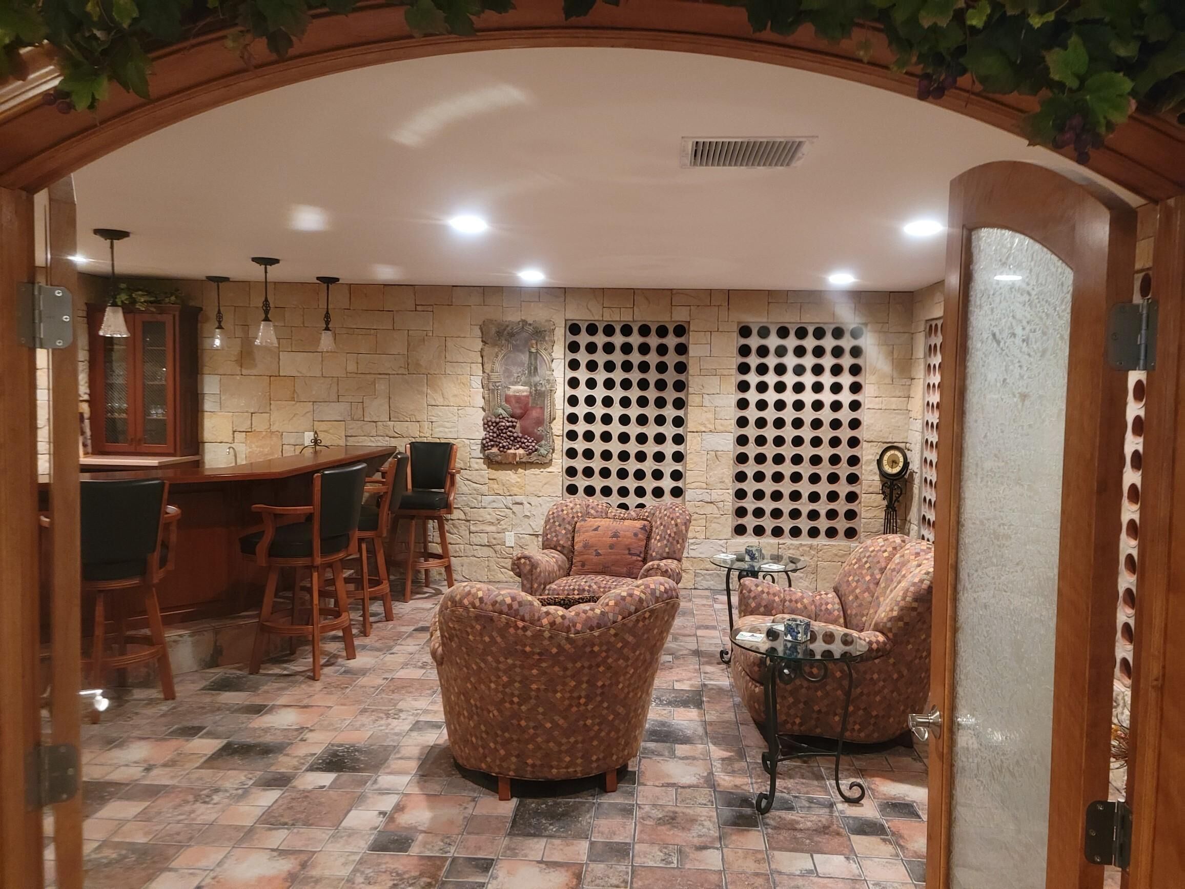 A cozy indoor seating area with a stone wall, patterned sofas, and a wooden dining table.
