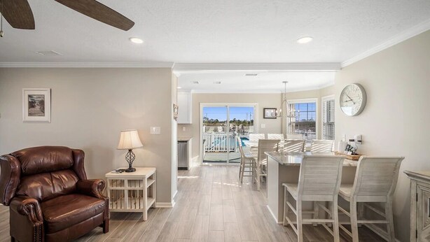 A spacious living room with a leather sofa, a dining area with a glass table, and a view of a balcony. - Awesome views of the Gulf, Easy walk to the beach and Private  Pool! (Gulf Shores)