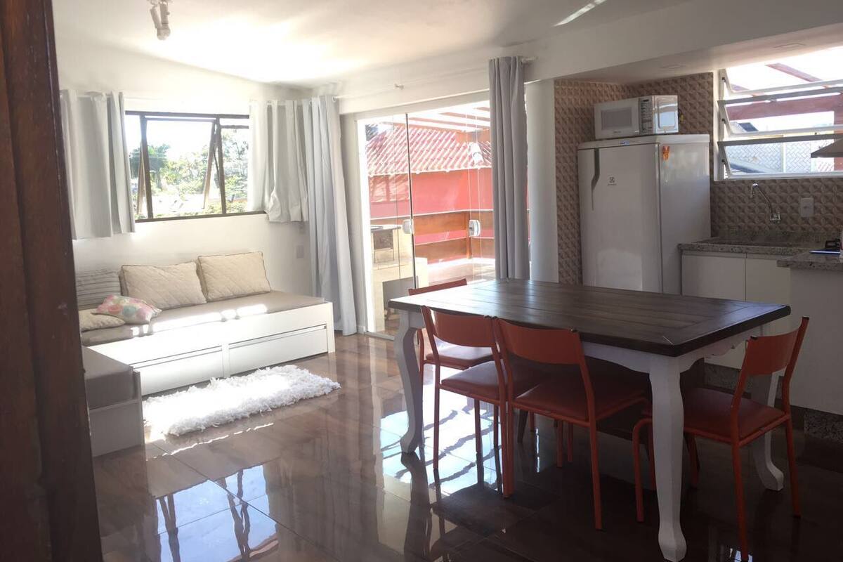 A modern kitchen with a dining area, a refrigerator, and a microwave.