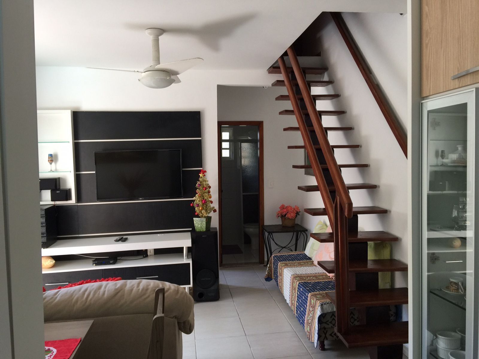 Una sala moderna con televisor de pantalla plana, una escalera de madera y un comedor.