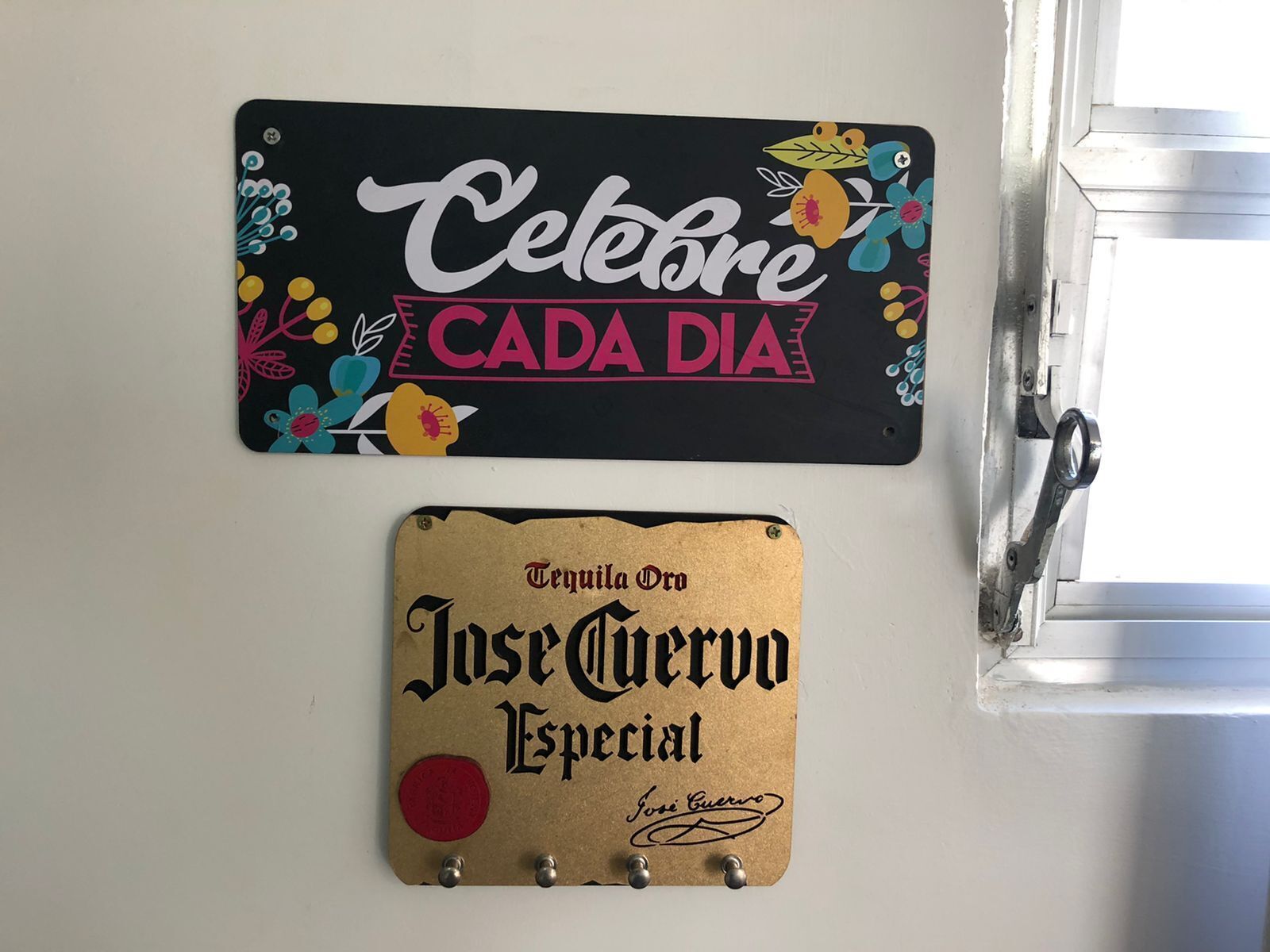 Two signs: one says "Celebre Cada Dia" with colorful floral designs, and the other says "Tequila On Jose Guerrero Especial" with a signature.