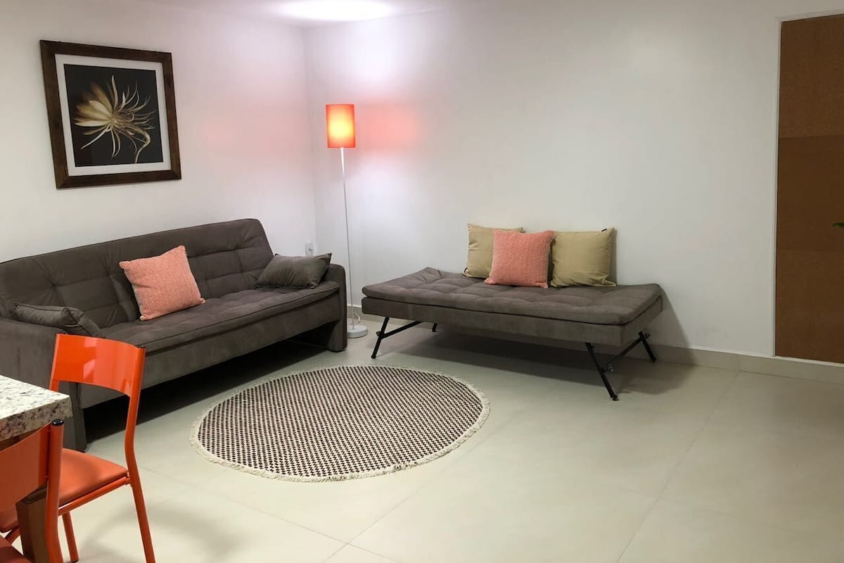 A modern living room with two sofas, a dining table, and a chair.