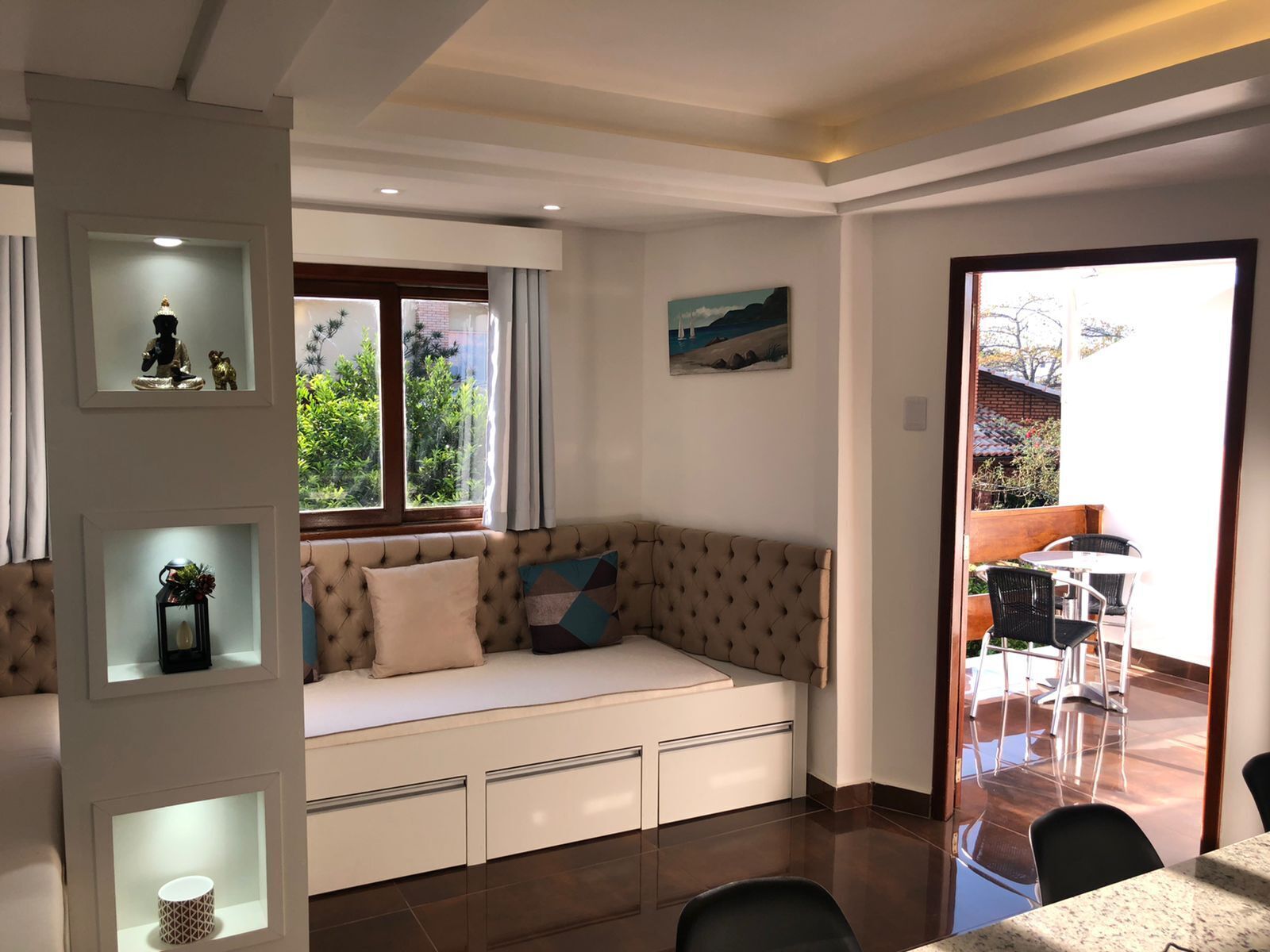 Una sala de estar moderna con un sofá, una mesa de comedor y vistas al exterior.