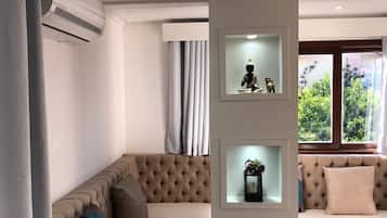 Apartamento luxo, várias camas | Sala de estar | TV 82 cm com canais digitais, serviços de streaming