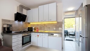 Een koffiezetapparaat/waterkoker, een koelkast, een magnetron, een oven