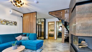 Ein modernes Wohnzimmer mit einem blauen Sofa, einem Couchtisch und einem Kamin.