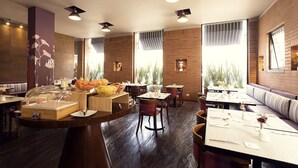 Un restaurante con suelo de madera, varias mesas para comer y diferentes opciones de asientos, incluyendo cabinas y sillas.