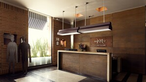 Una moderna zona de recepción con un mostrador de madera, un ventanal con vistas, y un mostrador de recepción con un cartel que dice “Merit”.