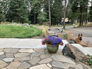 Enjoy a peaceful retreat in our serene outdoor space, featuring a stone pathway, lush greenery, and a seating area perfect for relaxation.