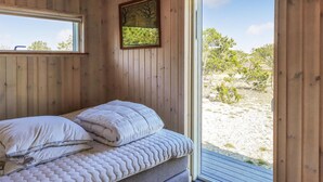 A wooden cabin bedroom with a bed, a window, and a view of the outdoors. - Amazing home in Anholt with WiFi (Anholt)