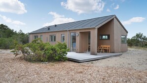 A modern wooden house with a sloped roof, large windows, and a wooden deck. - Amazing home in Anholt with WiFi (Anholt)