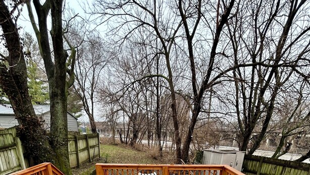 A wooden deck with outdoor furniture, including a round table and sofas, and a grill. - Breaking Records - Steps from Paristown Hall (Louisville)