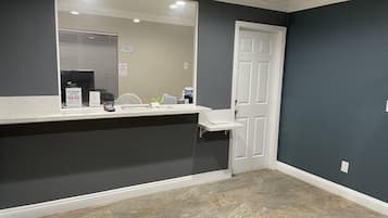 A bathroom with a large mirror, a sink, a toilet, and a door.
