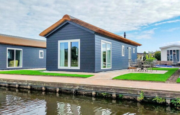 Situated by the water, this property offers scenic views and a patio area with outdoor furniture.