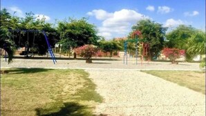 En legeplads med gyngestole og klatrestrukturer i en park.