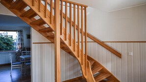 Una escalera de madera con barandilla que lleva a un piso superior.
