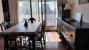 A dining area with a table, chairs, a cabinet, and a view of the cityscape through large windows. -  Prime location Downtown Vancouver (Vancouver)