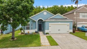 A residential house with a light blue exterior, a front garage, and a well-maintained lawn. - 4 Bedrooms/2 Bathrooms AMAZING HOME! PRIVATE POOL! (Kissimmee)