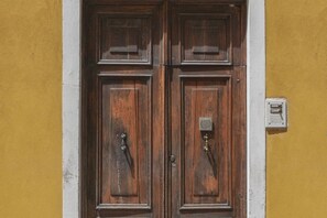 Perinteisellä tyylillä koristeltu puinen pariovet, joka on sijoitettu keltaiseen seinään.