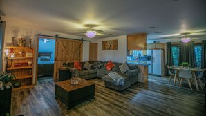 A cozy living room with a sofa, coffee table, and a dining area with a table and chairs. - Simplicity (Broken Bow)