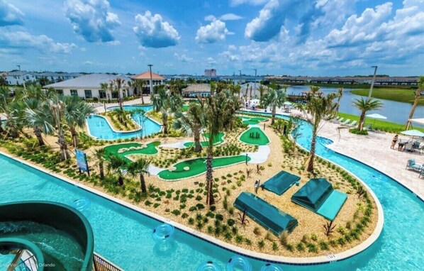 A resort with multiple swimming pools, palm trees, and a golf course.