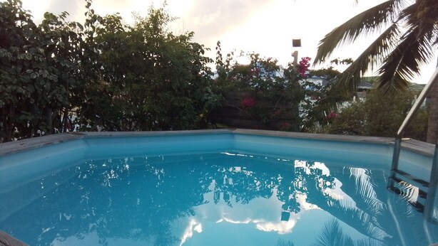 Ein rechteckiger Swimmingpool mit einer umlaufenden Holzterrasse.